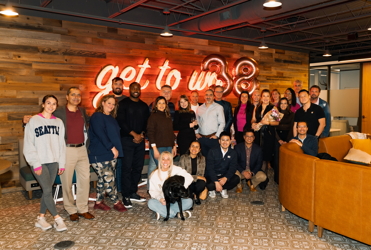 Lu Hickman Creative Co. team, clients, and friends gathered under a 'get to us' neon sign for the studio's eighth anniversary soirée